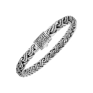 Sterling silver twisted rope chain bracelet featuring wrapped textured links, deep oxidized accents, polished detailing, and an engraved decorative push clasp.