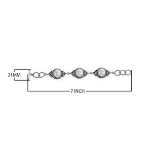 Sterling silver bracelet featuring carved bone faces with Garnet Quartz and Blue Topaz Quartz accents and an artisan toggle lock.
