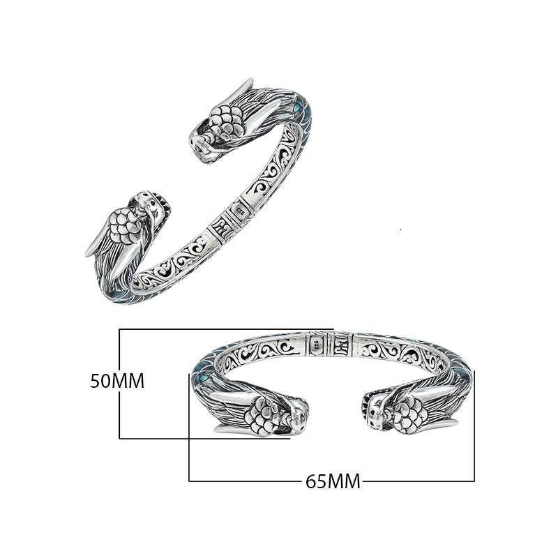 Wholesale sterling silver phoenix cuff bangle featuring Abalone Shell accents, intricate Balinese scroll engraving, and a secure hinge lock for detailed artisan presentation.