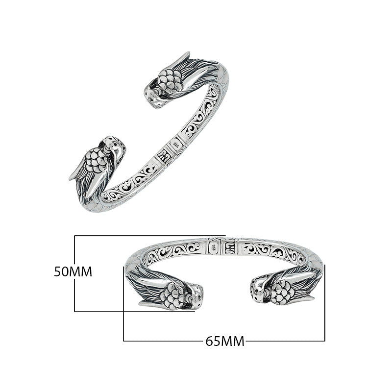 Wholesale sterling silver phoenix bangle featuring Mother of Pearl accents, detailed Balinese scroll carving, and a secure hinge lock ideal for premium artisan jewelry collections.