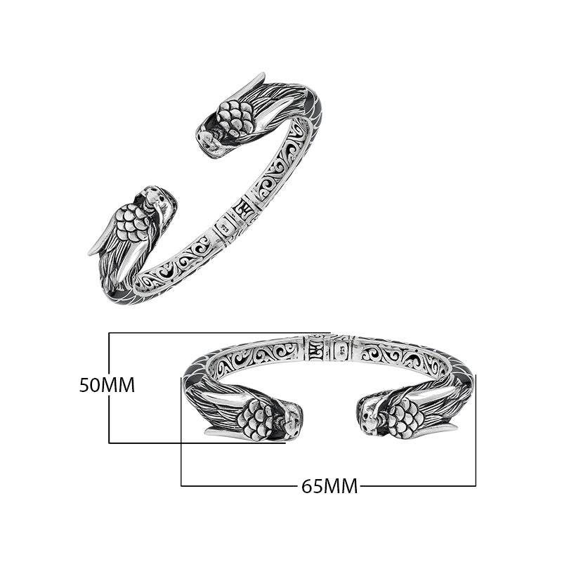 Wholesale sterling silver phoenix bangle featuring Black Shell insets, ornate Balinese scroll carving, and a sturdy hinge lock, crafted for premium artisan wholesale jewelry assortments.