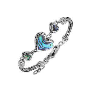 Wholesale sterling silver bracelet featuring Abalone Shell heart links, intricate Balinese decorative detailing, and a secure lobster lock for premium artisan-style jewelry collections.