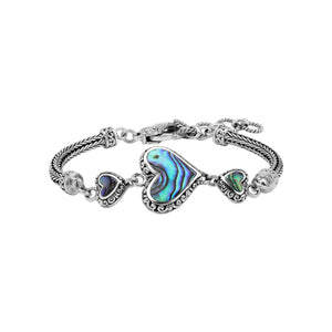 Wholesale sterling silver bracelet featuring Abalone Shell heart links, intricate Balinese decorative detailing, and a secure lobster lock for premium artisan-style jewelry collections.