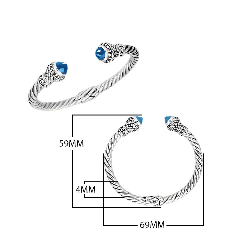 Wholesale sterling silver twisted cable cuff bracelet with faceted blue topaz quartz end caps, hinge lock, and ornate Balinese engravings for premium jewelry collections.
