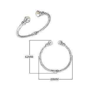 Wholesale sterling silver twisted cable cuff bracelet featuring smooth Mabe pearl end caps, hinge lock, and artisan detailing for premium jewelry assortments.