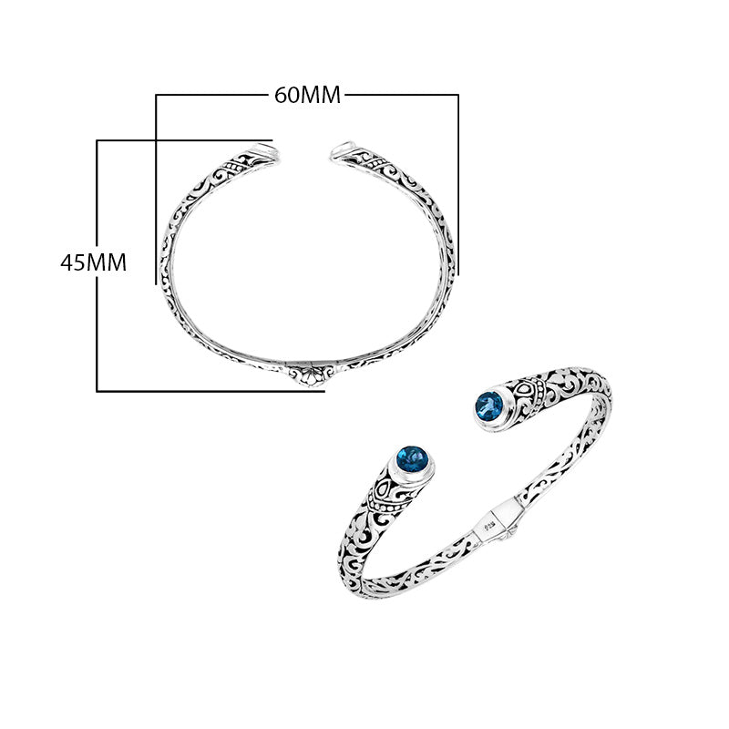 Wholesale sterling silver Bali engraved hinge cuff bracelet featuring sparkling blue topaz quartz ends and polished–oxidized detailing, crafted for premium artistic wholesale jewelry assortments and elevated inventory selections.