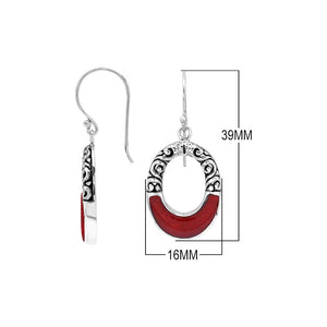 Sterling silver oval drop earrings featuring rich Red Coral inlay, open center design, sculpted scroll motifs, oxidized detailing, polished borders, and French ear wires.