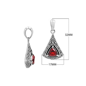 Triangular sterling silver pendant featuring red garnet quartz trillion-cut centerpiece, geometric Balinese engravings, and smooth high-gloss polish.