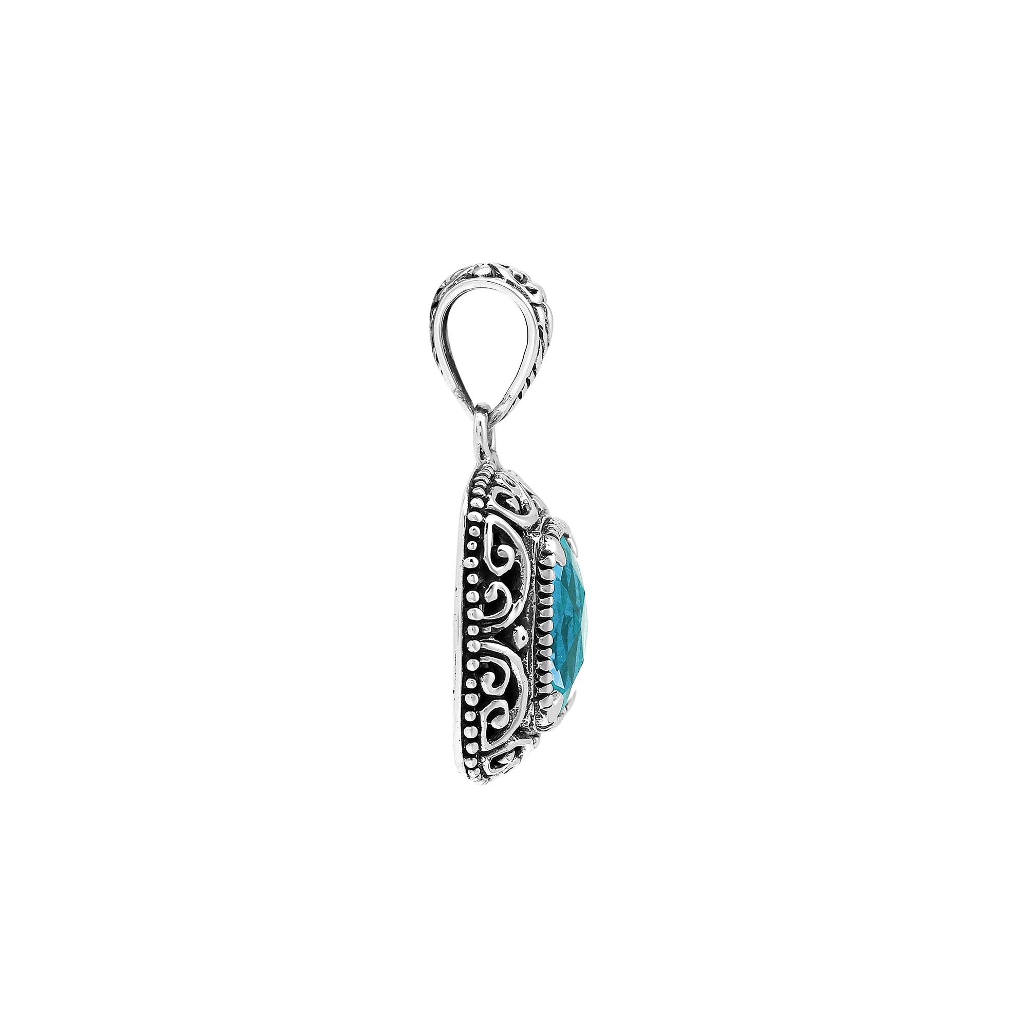 Sterling silver cushion pendant featuring a faceted Blue Topaz Quartz centerpiece accented with intricate Balinese scroll carvings and a polished decorative frame.