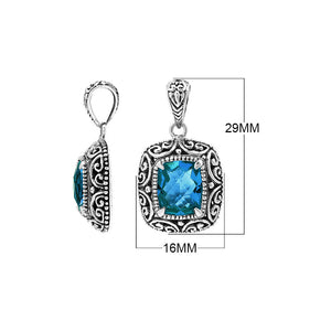 Sterling silver cushion pendant featuring a faceted London Blue Topaz Quartz centerpiece accented with ornate Balinese scroll carvings and a polished decorative frame.