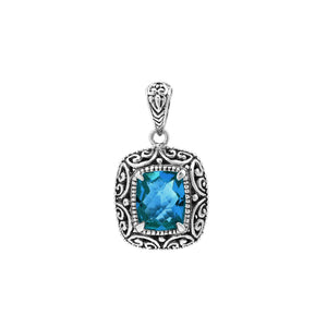 Sterling silver cushion pendant featuring a faceted London Blue Topaz Quartz centerpiece accented with ornate Balinese scroll carvings and a polished decorative frame.