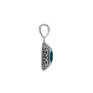 Sterling silver cushion pendant featuring a faceted London Blue Topaz Quartz centerpiece accented with ornate Balinese scroll carvings and a polished decorative frame.