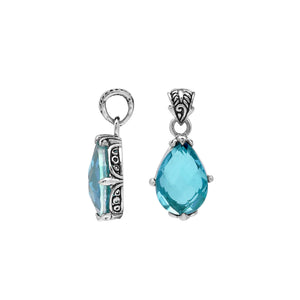 Sterling silver pear-shaped pendant featuring a faceted Blue Topaz Quartz centerpiece with polished prong-setting and intricate Balinese carved detailing.