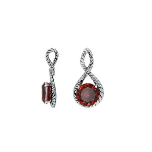 Sterling silver twisted loop pendant featuring a round faceted Red Garnet Quartz centerpiece with carved Balinese detailing and polished artistic round setting.