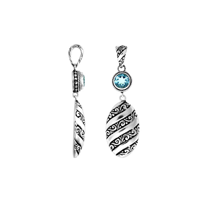 A wholesale Silver Overlay Over Copper pendant featuring a sparkling blue topaz quartz stone, detailed Balinese spiral patterns, oxidized textures, and polished highlights ideal for bulk jewelry purchasing.