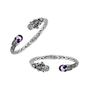 A wholesale sterling silver octopus-inspired bangle featuring a vivid amethyst quartz stone, intricate Balinese carvings, oxidized detailing, and a secure hinge lock mechanism ideal for bulk jewelry buying.