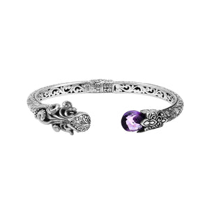 A wholesale sterling silver octopus-inspired bangle featuring a vivid amethyst quartz stone, intricate Balinese carvings, oxidized detailing, and a secure hinge lock mechanism ideal for bulk jewelry buying.