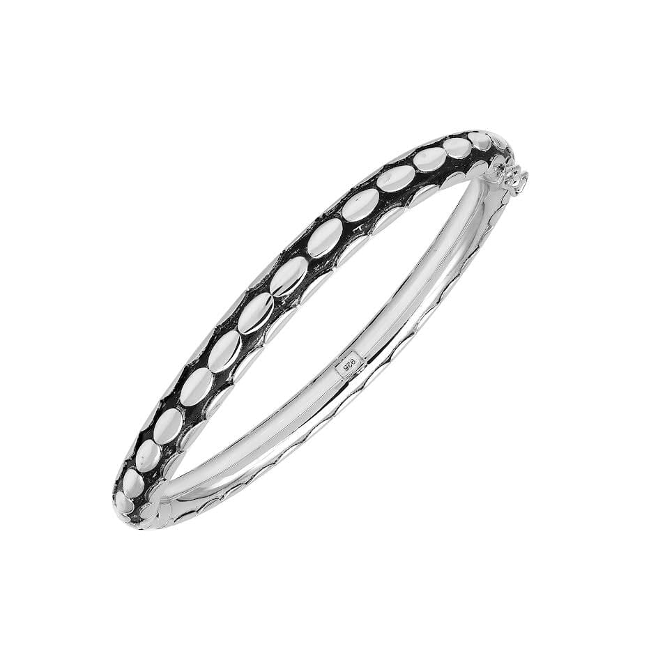 Sterling silver medium-size bangle featuring bold oval textured detailing, polished and oxidized finish, and secure hinge lock with safety latch for wholesale jewelry buyers.