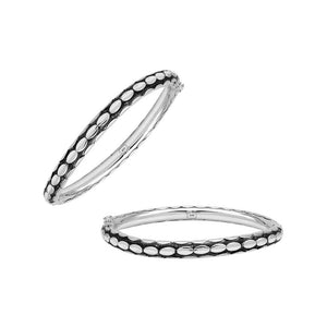 Sterling silver medium-size bangle featuring bold oval textured detailing, polished and oxidized finish, and secure hinge lock with safety latch for wholesale jewelry buyers.