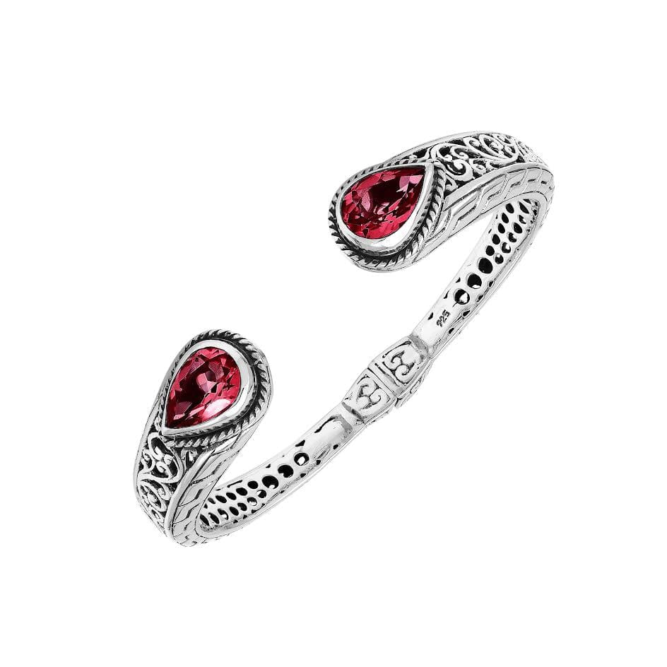 Sterling silver bangle with teardrop red garnet quartz stones, detailed Bali engraving, oxidized texture, and secure hinge lock crafted for wholesale jewelry collections.