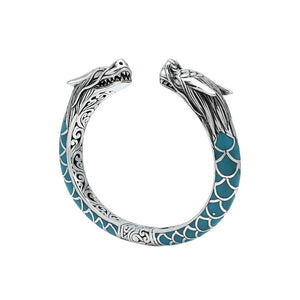 Wholesale sterling silver phoenix bangle featuring Turquoise Shell accents, ornate Balinese scroll engravings, and a secure hinge lock crafted for premium artisan wholesale jewelry collections.