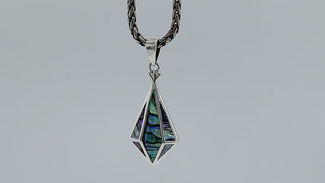 A handcrafted sterling silver pendant featuring a luminous Abalone Shell in a geometric triangular pattern, showcasing a fusion of modern and Balinese artistry.