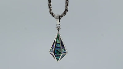 A handcrafted sterling silver pendant featuring a luminous Abalone Shell in a geometric triangular pattern, showcasing a fusion of modern and Balinese artistry.