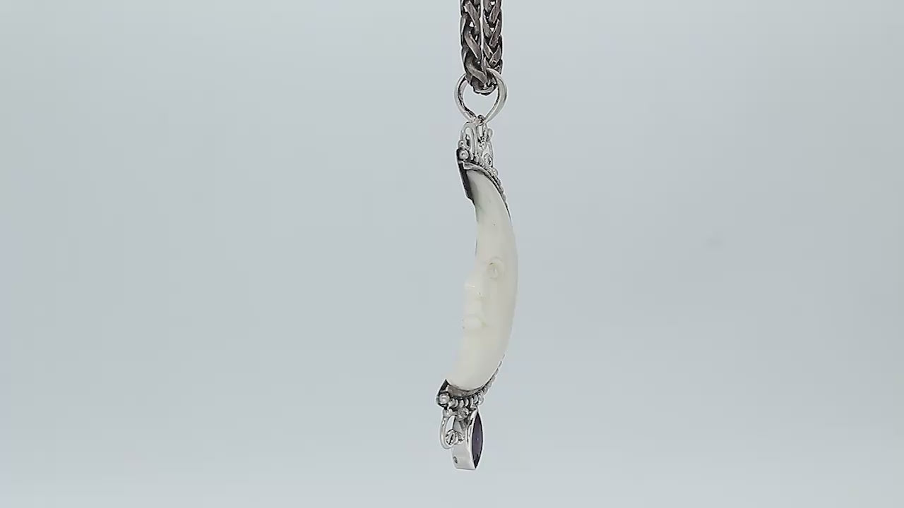 Sterling silver half-moon pendant with carved bone face and amethyst gemstone, Balinese design.