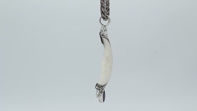 Sterling silver half-moon pendant with carved bone face and amethyst gemstone, Balinese design.
