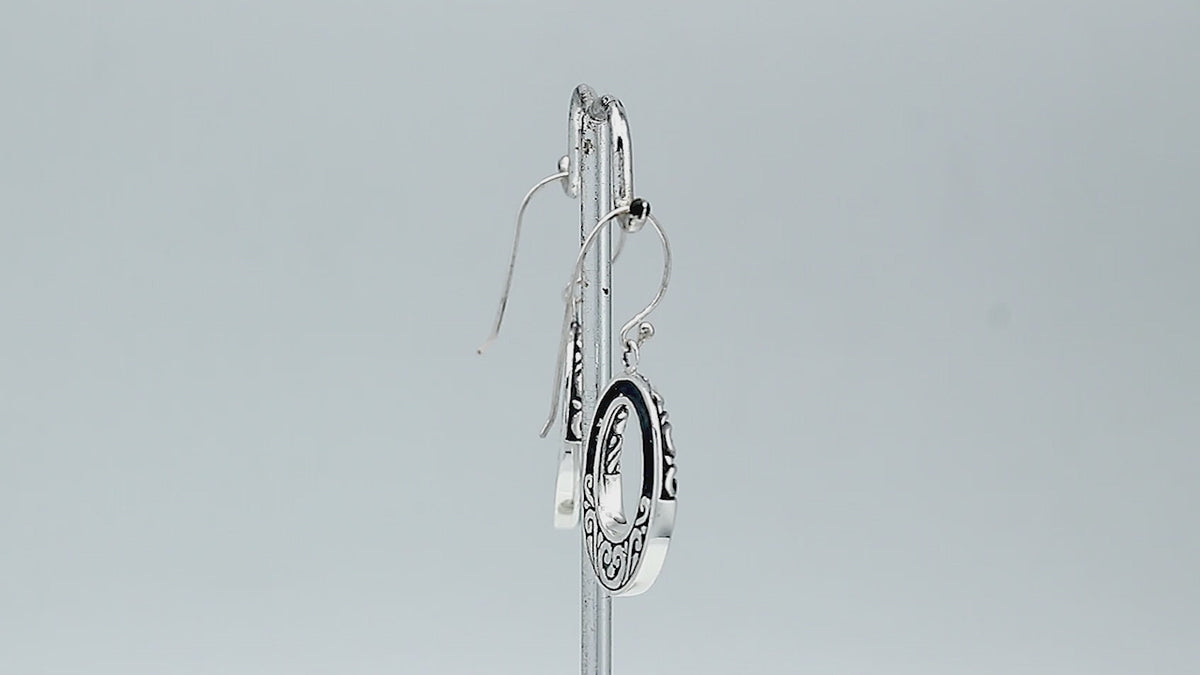 Sterling silver oval drop earrings featuring vibrant Turquoise Shell inlay, open center silhouette, sculpted scroll motifs, oxidized detailing, polished borders, and French ear wires.
