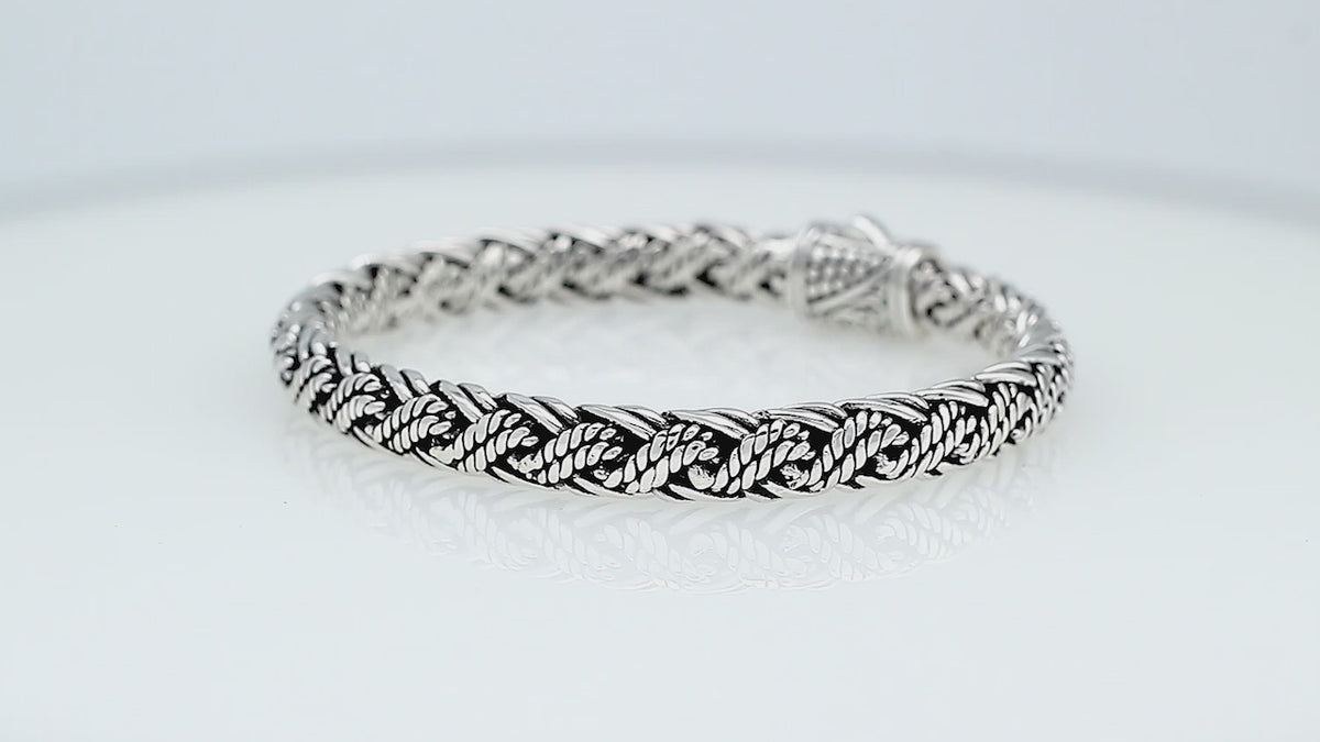 Sterling silver twisted rope chain bracelet featuring wrapped textured links, deep oxidized accents, polished detailing, and an engraved decorative push clasp.