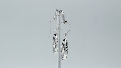 Sterling silver oval drop earrings featuring glossy Black Shell inlay, open center silhouette, sculpted scroll motifs, oxidized detailing, polished borders, and French ear wires.