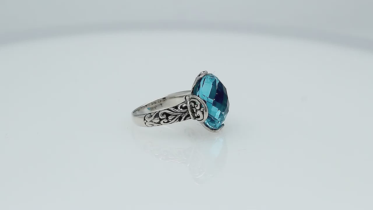 Sterling silver ring with faceted round Blue Topaz Quartz and Balinese scrollwork handcrafted in Bali.