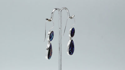 Sterling silver Abalone Shell dangle earrings featuring round upper settings and teardrop lower drops with vivid blue, green, violet, and turquoise iridescent patterns.