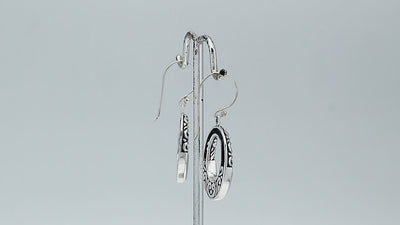 Sterling silver oval drop earrings featuring luminous Mother Of Pearl inlay, open center silhouette, decorative scrollwork, oxidized detailing, polished borders, and French ear wires.