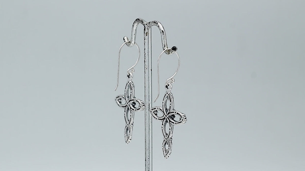 Sterling silver cross drop earrings featuring open oval sections, sculpted floral motifs, oxidized detailing, polished raised accents, and classic French ear wires.