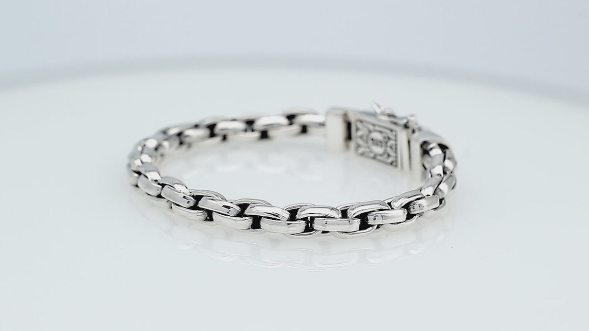 Sterling silver round braided link chain bracelet featuring substantial interwoven links, polished surfaces, oxidized accents, and an engraved decorative box clasp.