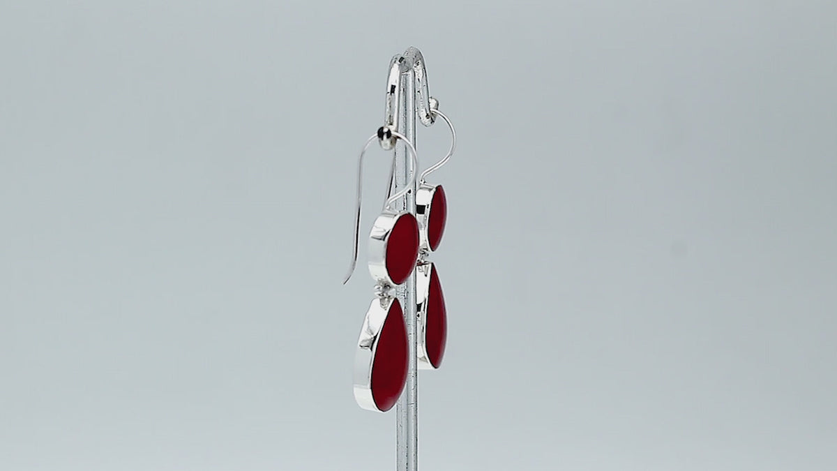 Sterling silver Red Coral dangle earrings featuring a round upper element and teardrop lower drop, polished bezel settings, articulated construction, and elongated ear wires.