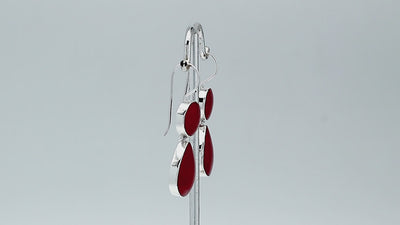 Sterling silver Red Coral dangle earrings featuring a round upper element and teardrop lower drop, polished bezel settings, articulated construction, and elongated ear wires.