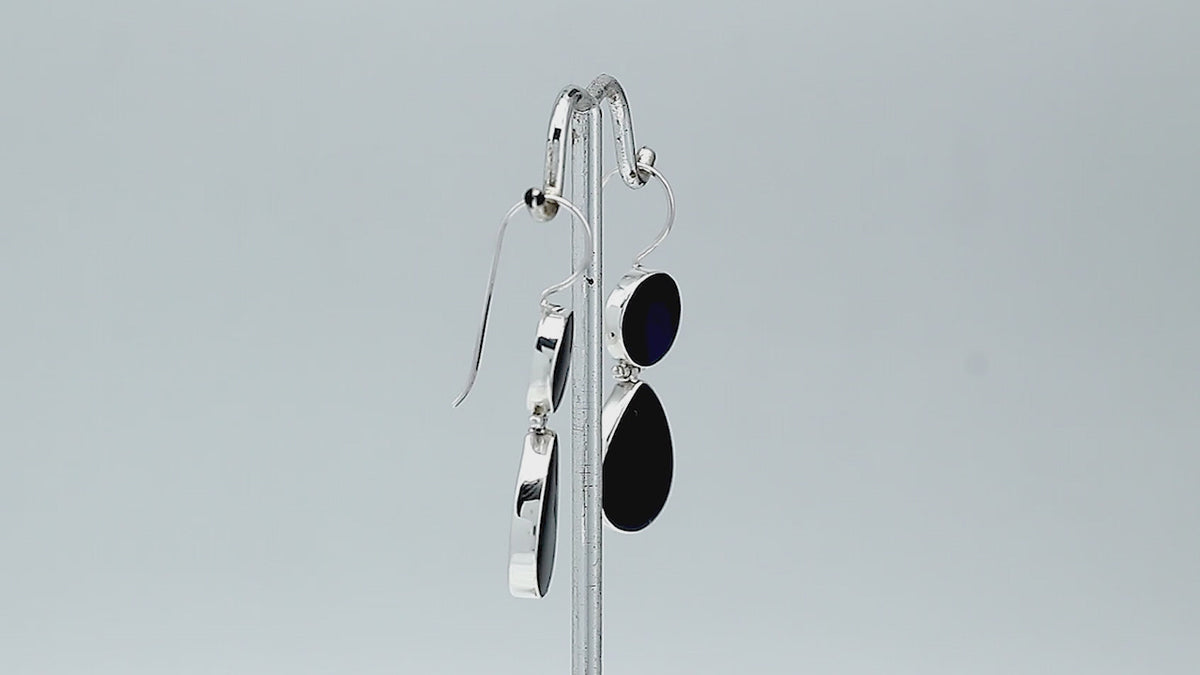 Sterling silver Black Shell dangle earrings featuring glossy round and teardrop elements, polished bezel settings, articulated double-drop construction, and elongated silver ear wires.