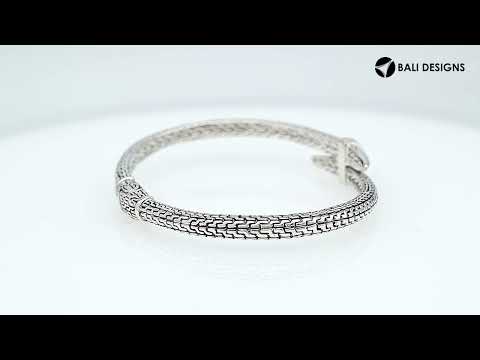 Wholesale sterling silver woven chain bangle featuring a sculpted nail-head design, intricate Balinese engravings, and a secure hinge lock for premium artisan jewelry assortments.