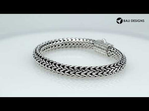 A wholesale sterling silver wide woven bracelet featuring an engraved push clasp, polished and oxidized detailing, and bold textured links crafted for premium bulk jewelry collections.