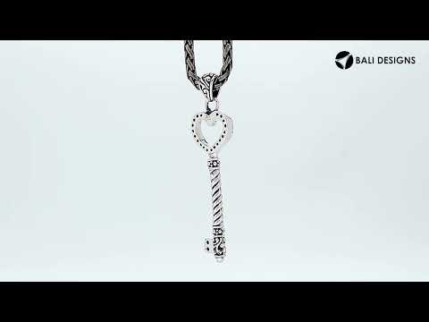 Sterling silver heart-shaped key pendant featuring dotted texturing, twisted stem detailing, and polished finishing suitable for classic wholesale jewelry displays