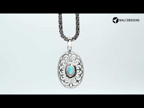 A handcrafted sterling silver pendant featuring a radiant Blue Topaz Quartz gemstone centered in an elegant Balinese filigree oval frame.