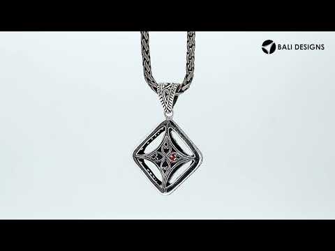 A handcrafted sterling silver pendant featuring a radiant Red Garnet Quartz in a Balinese filigree square frame with detailed silverwork.