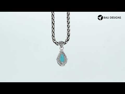 Sterling silver pear-shaped pendant featuring a faceted London Blue Topaz Quartz center with polished prong-setting and traditional Balinese carved ornamental detailing.