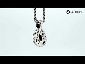 Sterling silver pendant featuring a teardrop Rainbow Moonstone set in a carved Balinese frame with a polished glossy finish.