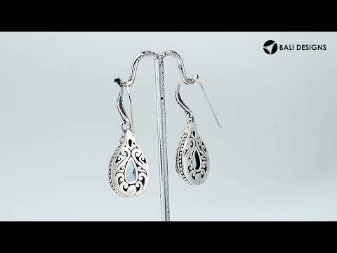 Wholesale sterling silver earrings featuring a deep-blue faceted Sapphire teardrop framed with ornate carved borders and secured with an earwire lock, offering regal brilliance and structured artisan appeal for premium wholesale presentations.