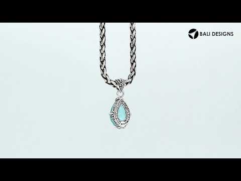 Sterling silver pear-shaped pendant featuring a faceted Blue Topaz Quartz centerpiece with polished prong-setting and intricate Balinese carved detailing.