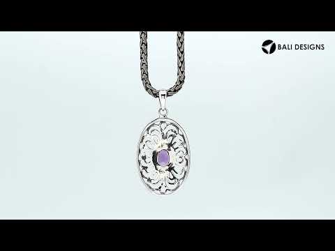A handcrafted sterling silver pendant featuring a radiant Amethyst Quartz centered in a detailed Balinese filigree oval frame.